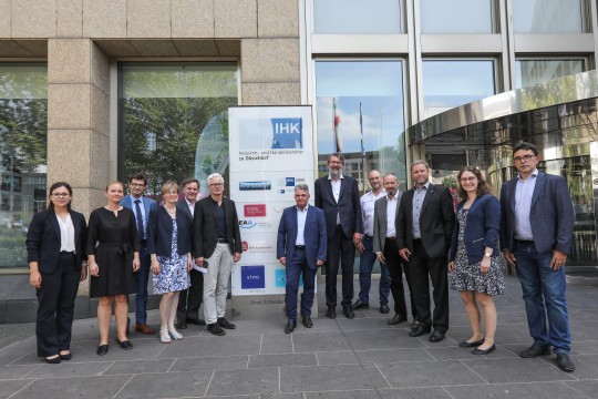 Das Foto zeigt eine Gruppe von Menschen vor dem Eingang der IHK Düsseldorf. Unter anderem zu sehen ist Martin Weiland, Sonderbeauftragter des Bundesministeriums für Arbeit und Soziales