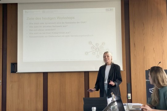 Auf dem Bild sind zwei Mitarbeiterinnen aus dem Forschungsprojekt der TU Dortmund zu sehen, die mit Hilfe einer PowerPoint-Präsentaion die Ziele des Workshops präsentieren.