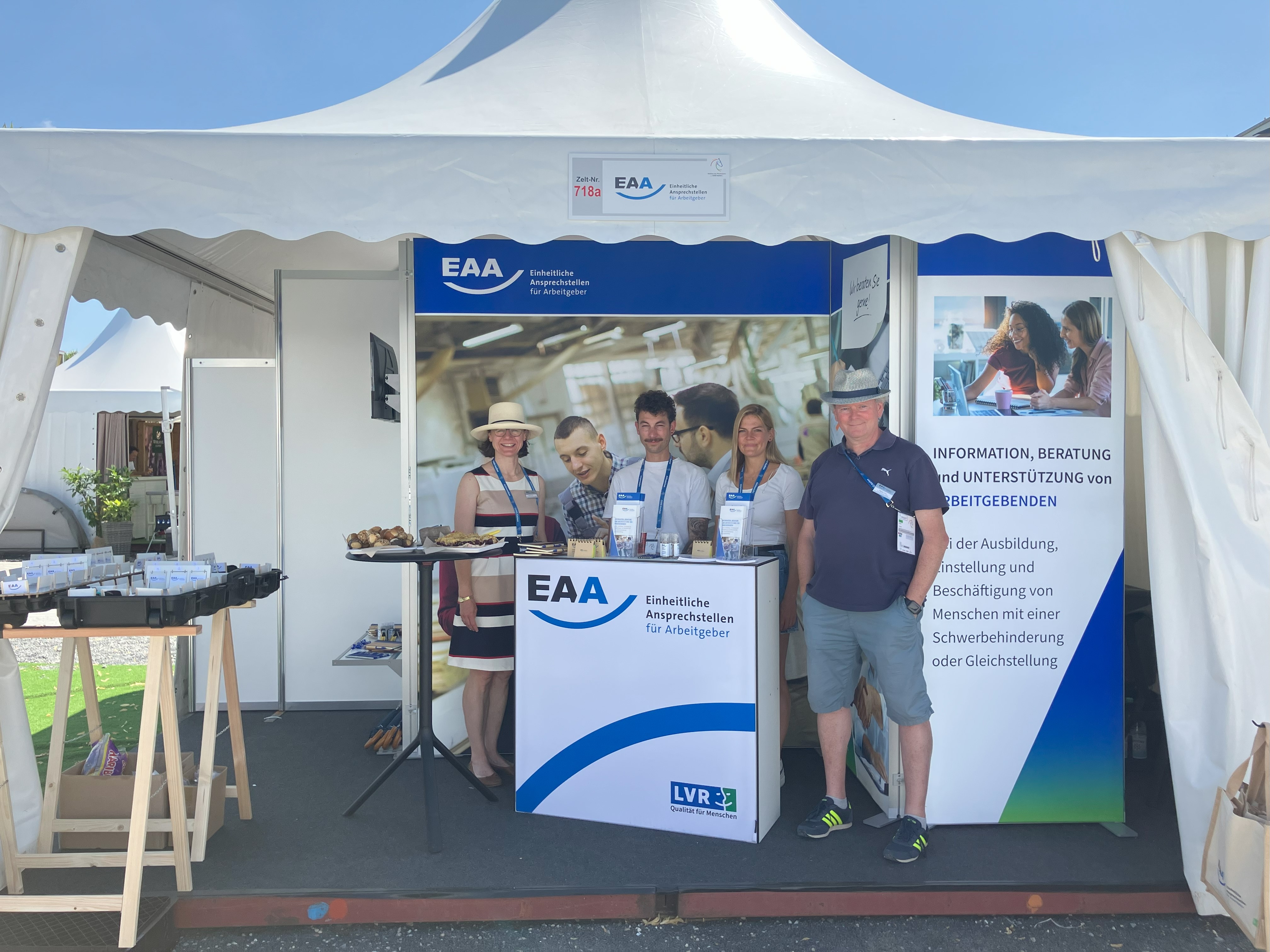 Auf dem Bild sich vier Fachberatende der EAA Rheinland an dem Infostand auf dem CHIO zu sehen.